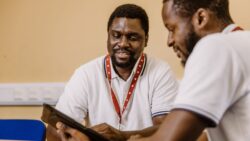 Two people reviewing information on a tablet together.