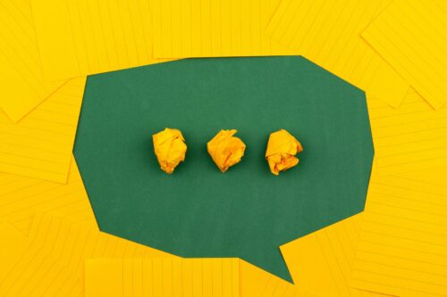 Speech bubble with crumpled paper symbols representing communication difficulties.
