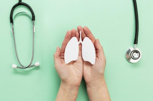 Lung health symbol held in hands beside a stethoscope.