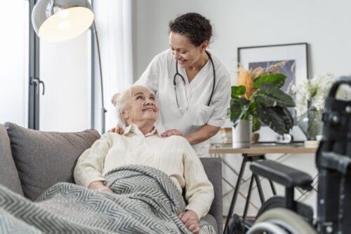 Healthcare professional supporting an older person at home.